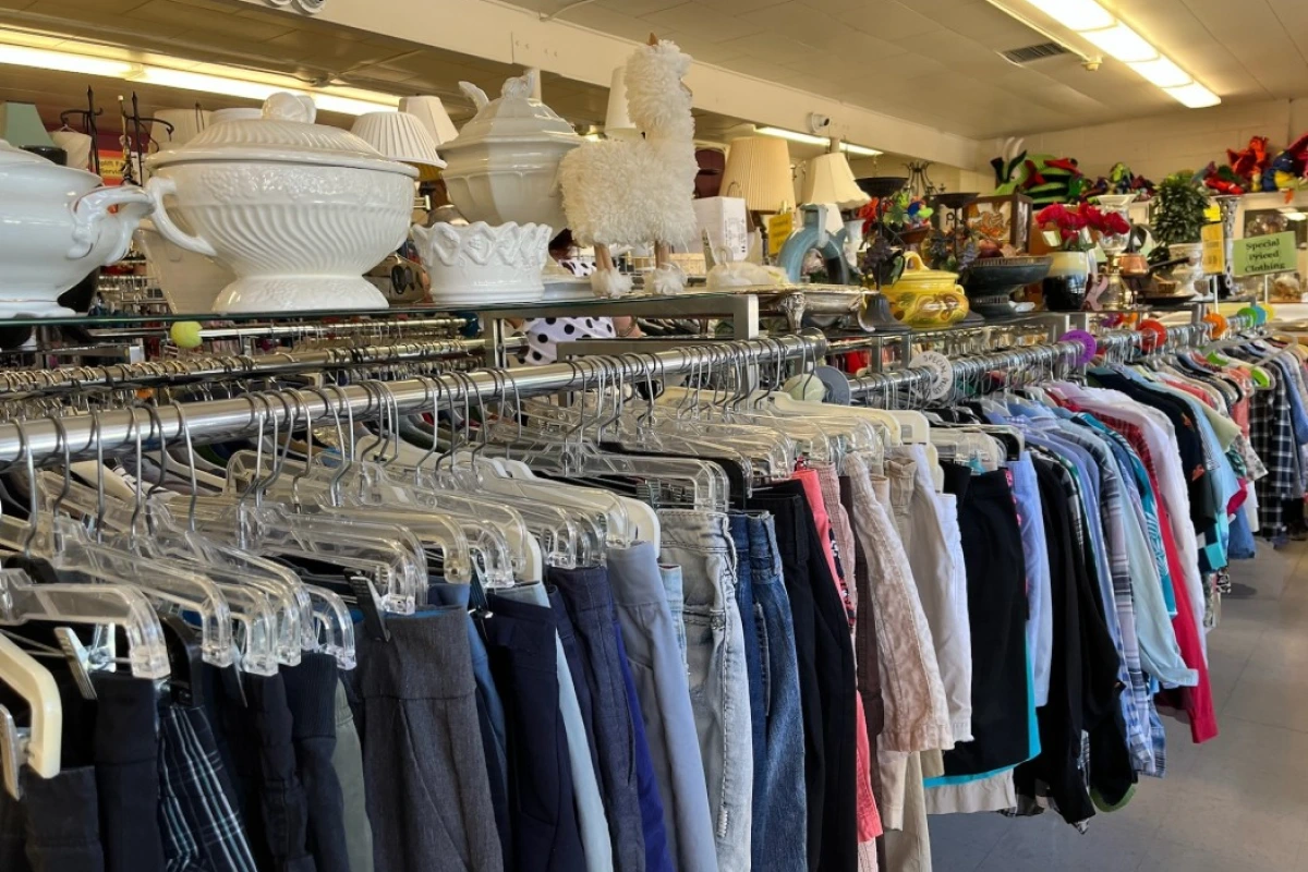 clothes hanging in a long bar on the thrift shop